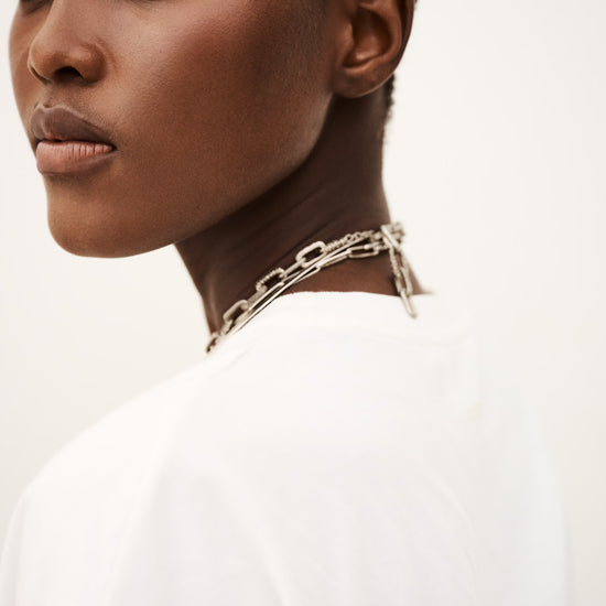 Woman wearing a silver chain necklace against a white background from ba&sh