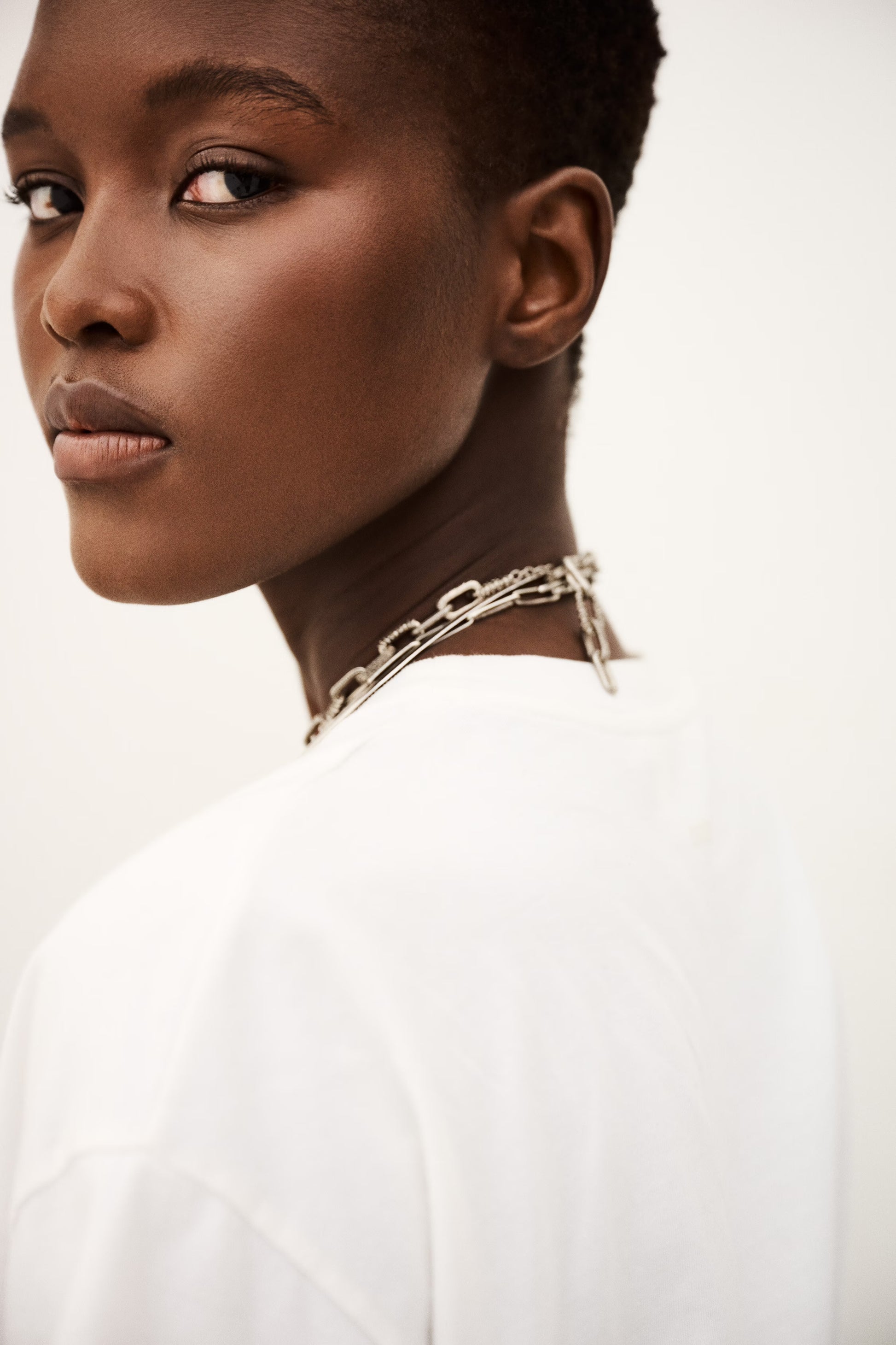 Woman wearing a silver chain necklace against a white background from ba&sh