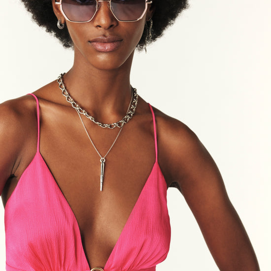 Fuchsia pink maxi dress with a deep v neckline and spaghetti straps that lace up the back