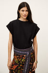 Woman wearing a black top and colorful patterned skirt on a white background from ba&sh