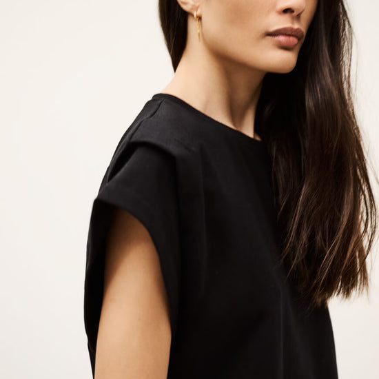 Woman wearing a black top against a plain background from ba&sh