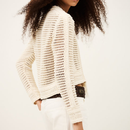 Woman wearing a white textured sweater against a plain background from bash