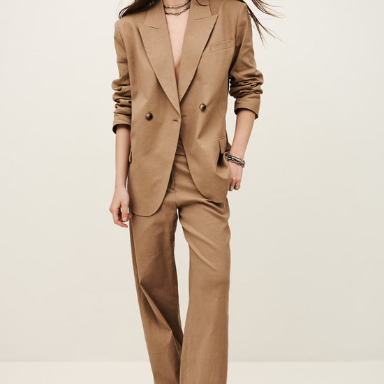 Woman wearing a beige suit against a white background
