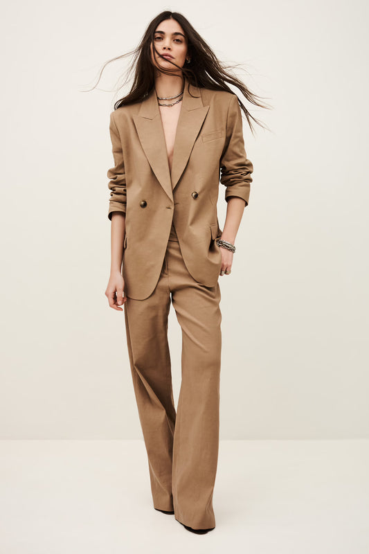 Woman wearing a beige suit against a white background