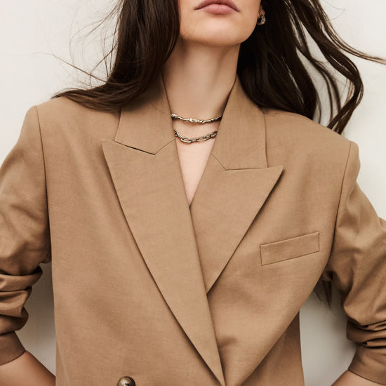 Woman wearing a beige blazer against a white background