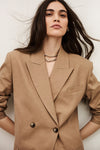 Woman wearing a beige blazer against a white background