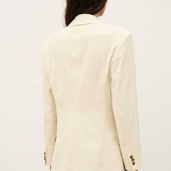 Person wearing a cream blazer on a plain background from ba&sh