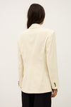 Person wearing a cream blazer on a plain background from ba&sh