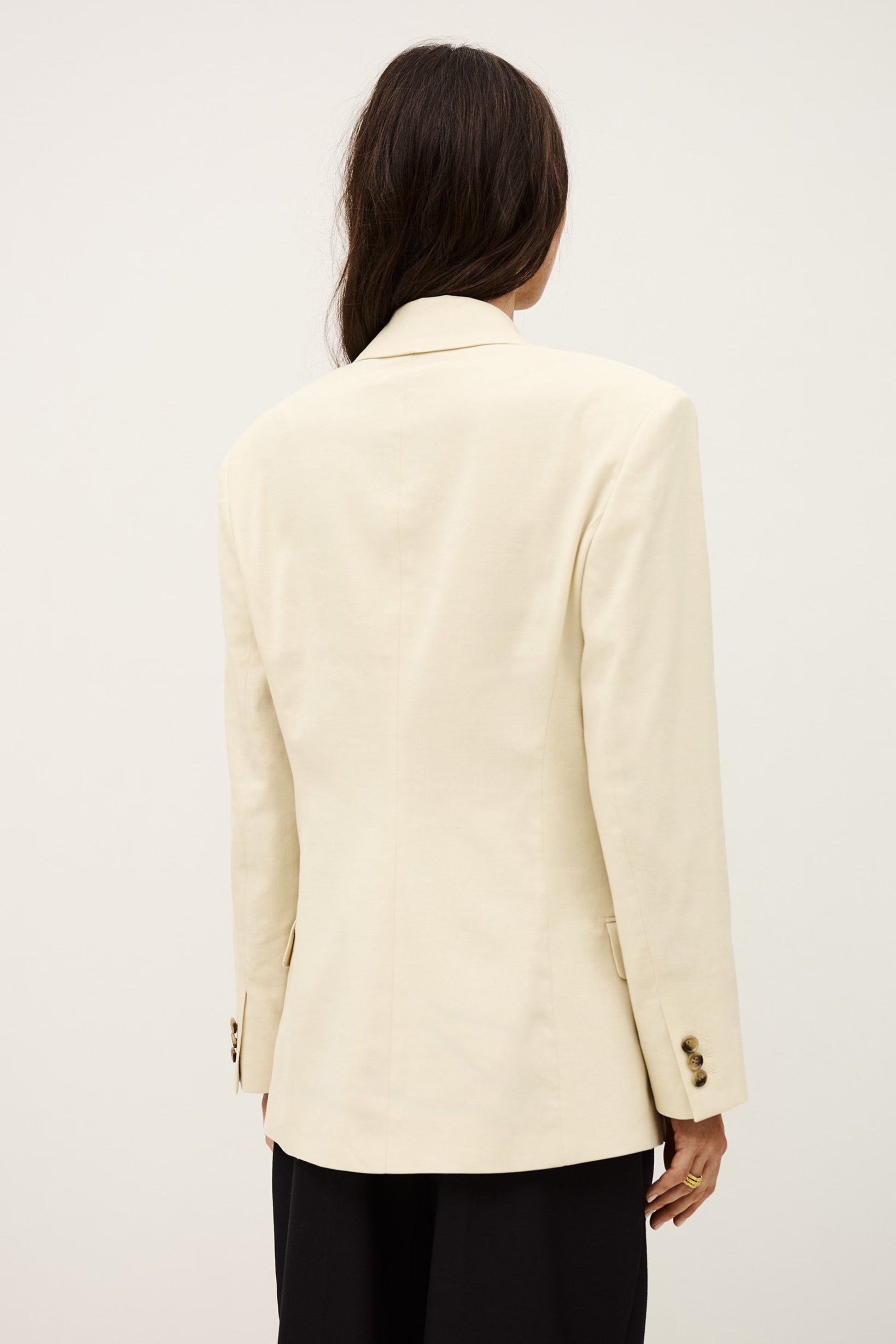 Person wearing a cream blazer on a plain background from ba&sh