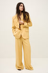 Woman wearing a yellow suit against a white background from ba&sh