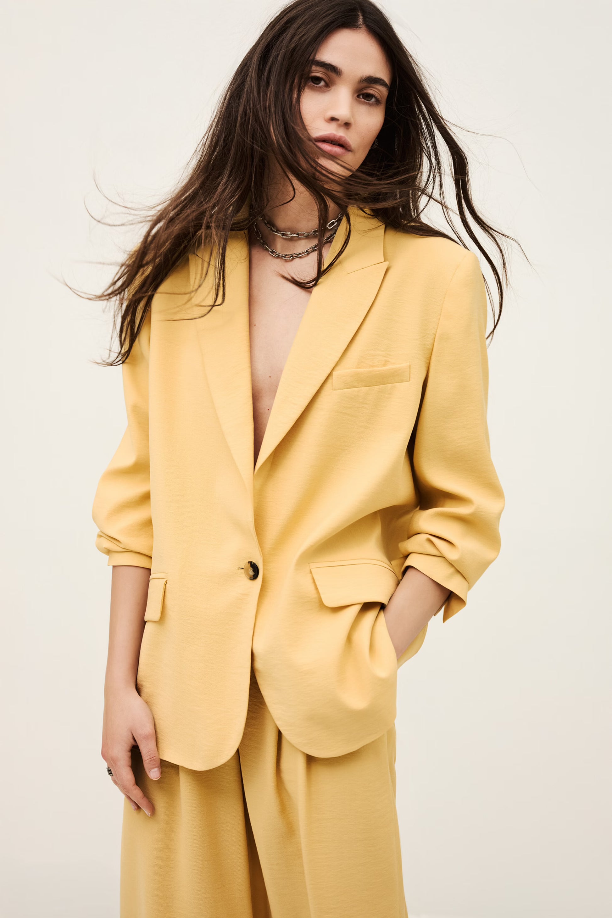 Woman wearing a yellow suit against a white background from ba&sh