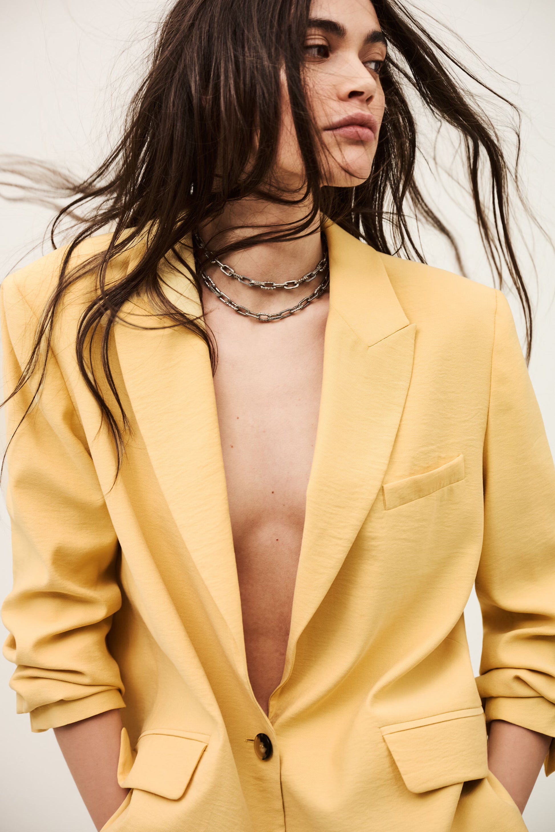 Person wearing a yellow suit with a plunging neckline against a neutral background from ba&sh