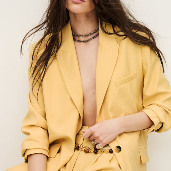 Woman wearing a yellow suit with a white background from ba&sh