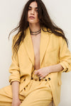 Woman wearing a yellow suit with a white background from ba&sh