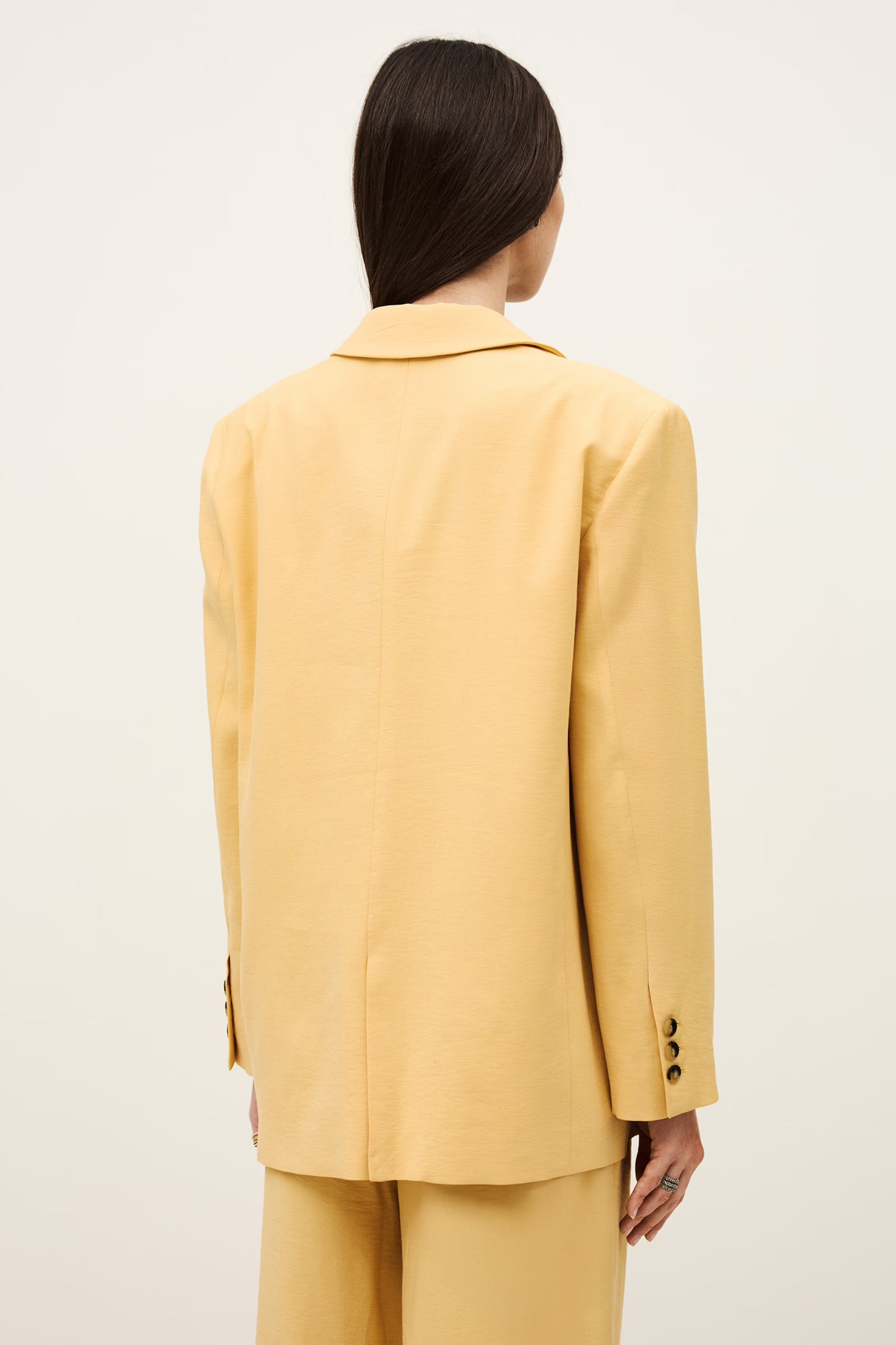 Person wearing a yellow suit against a white background from ba&sh