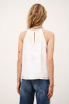 Rear view of white top with lace inserts worn with denim