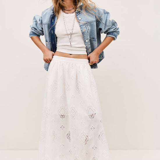 White skirt with lace inserts worn with the matching top and a denim jacket from ba&sh