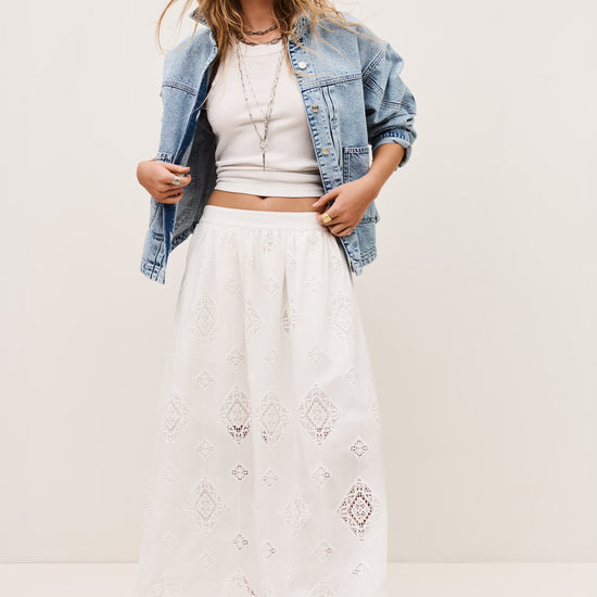 White skirt with lace inserts worn with white vest tee and denim jacket from ba&sh