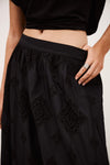 Close up detail of black cotton skirt with lace inserts