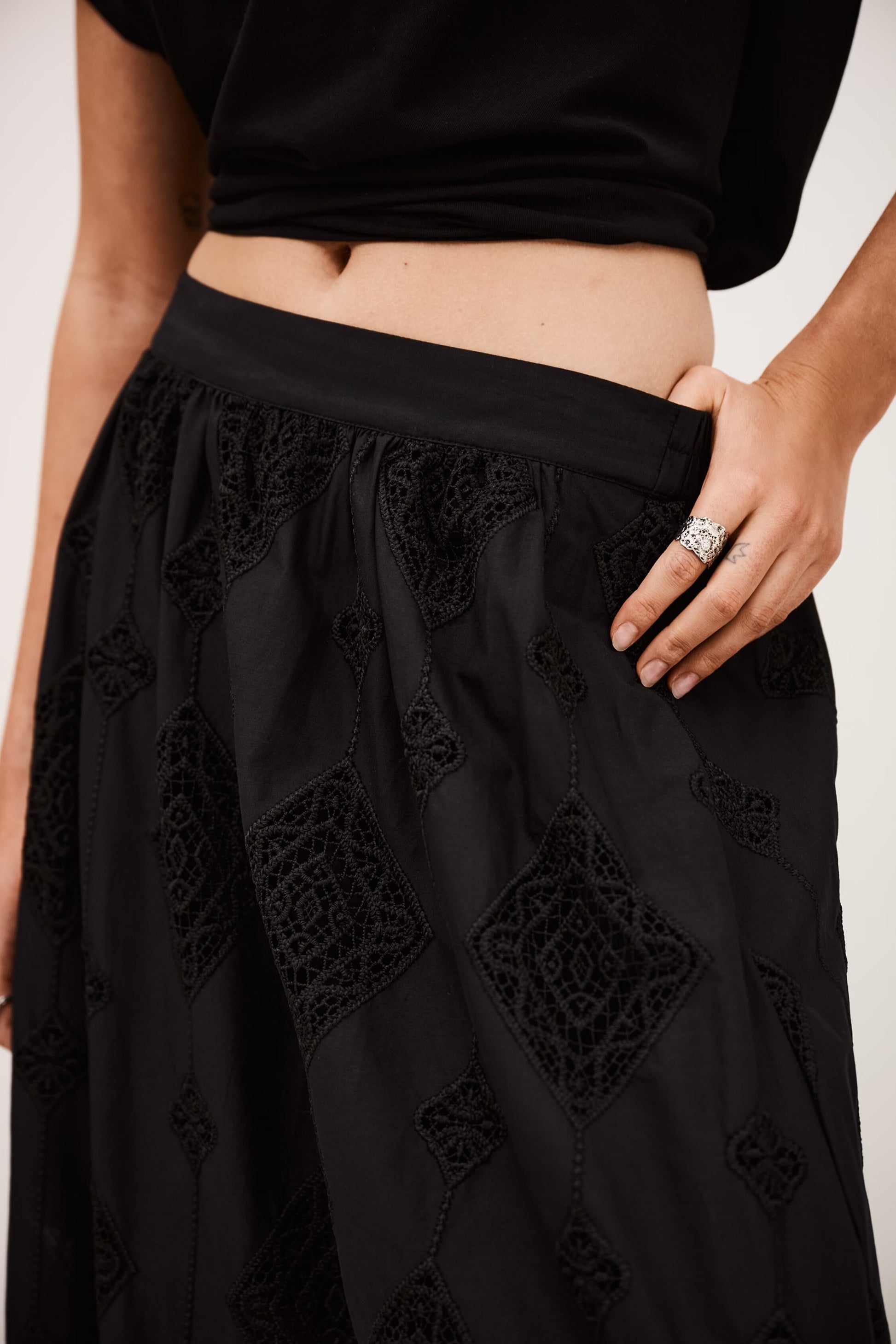 Close up detail of black cotton skirt with lace inserts