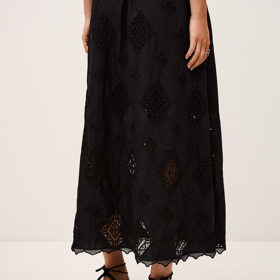 Black embroidered skirt worn by a person on a white background