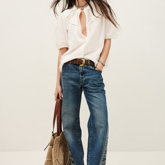 model in white shirt with lace inserts worn with jeans from ba&sh