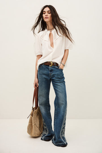 model in white shirt with lace inserts worn with jeans from ba&sh