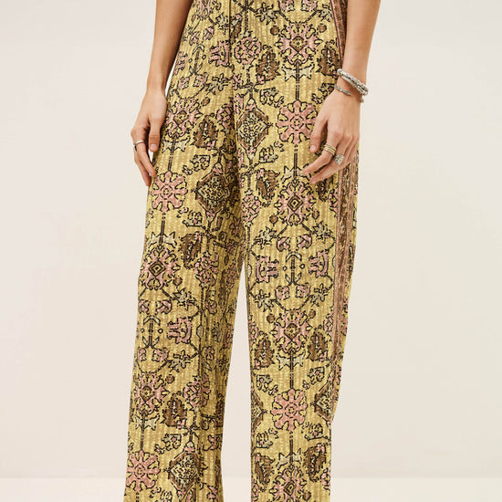 Person wearing a yellow floral jumpsuit on a plain background from ba&sh