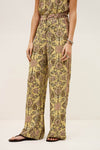 Person wearing a yellow floral jumpsuit on a plain background from ba&sh