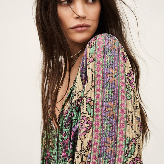 Woman wearing a colorful patterned scarf on a plain background from ba&sh