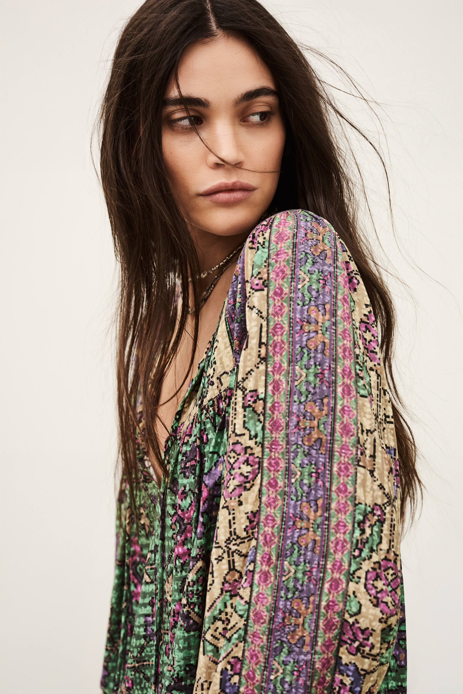 Woman wearing a colorful patterned scarf on a plain background from ba&sh