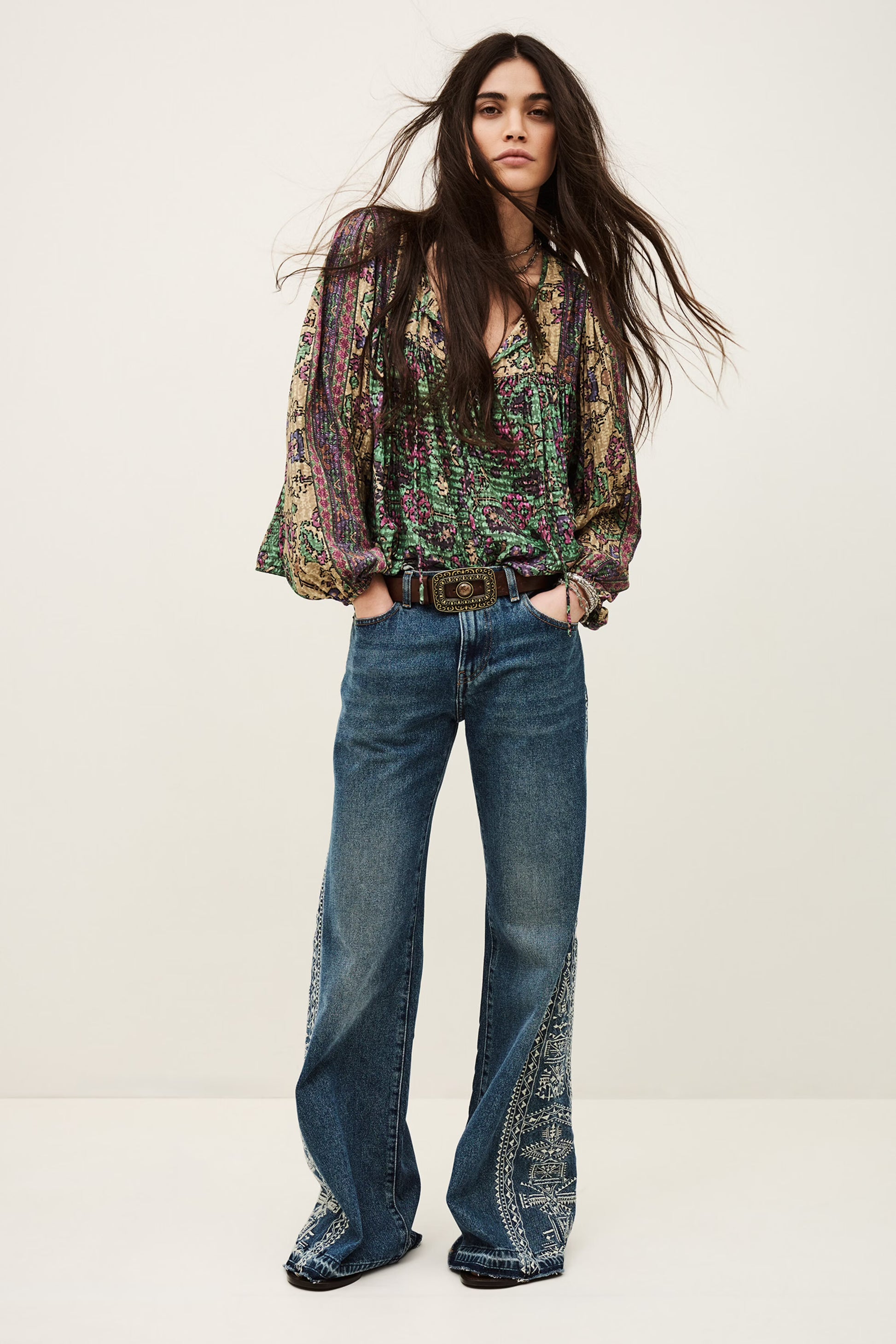 Woman wearing a patterned blouse and blue jeans on a white background from ba&sh