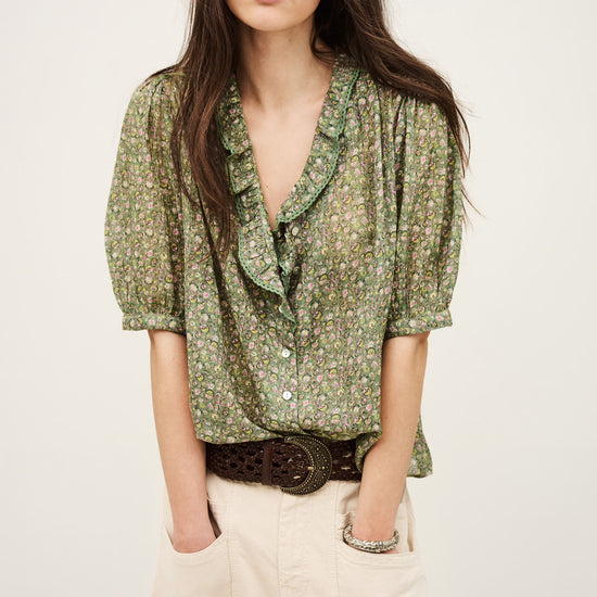 Woman wearing a green floral blouse with a plain background from ba&sh