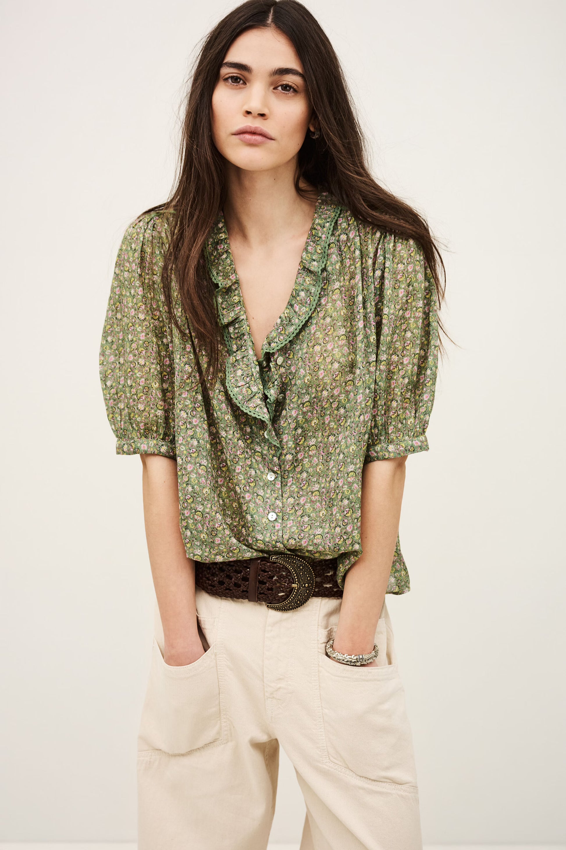 Woman wearing a green floral blouse with a plain background from ba&sh