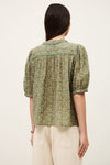 Woman wearing a green floral blouse with puffed sleeves on a white background from ba&sh