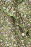 Close-up of a green floral patterned fabric with a button from ba&sh