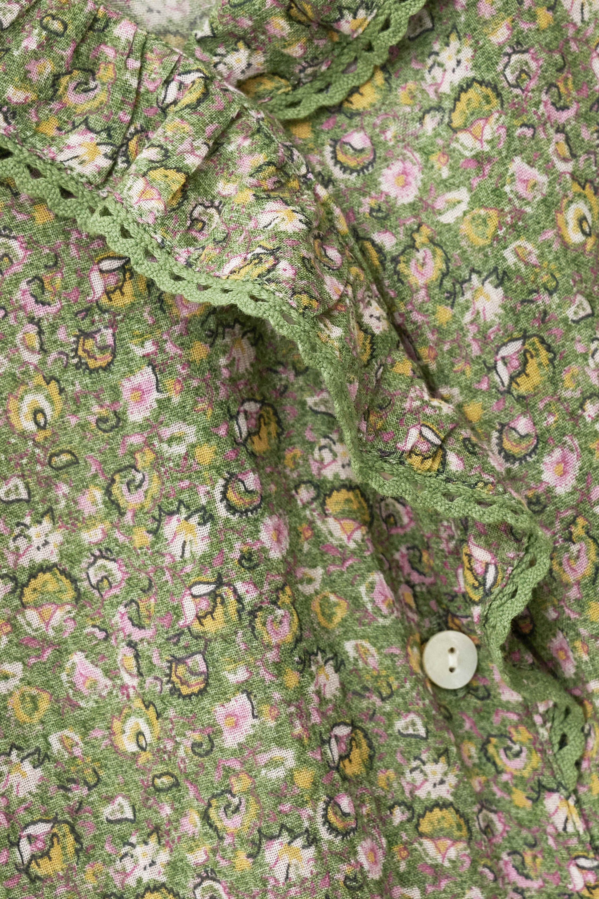 Close-up of a green floral patterned fabric with a button from ba&sh