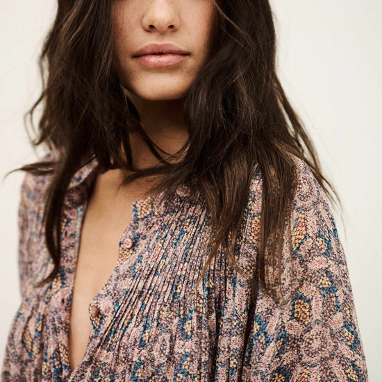 Woman wearing a patterned dress against a plain background from bash