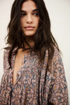 Woman wearing a patterned dress against a plain background from bash