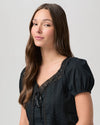 black cotton top with short sleeves, lace detailing and tie at the bust close up