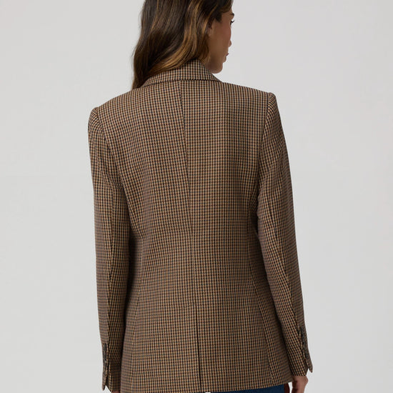 Rear view of brown dog tooth blazer worn with blue jeans