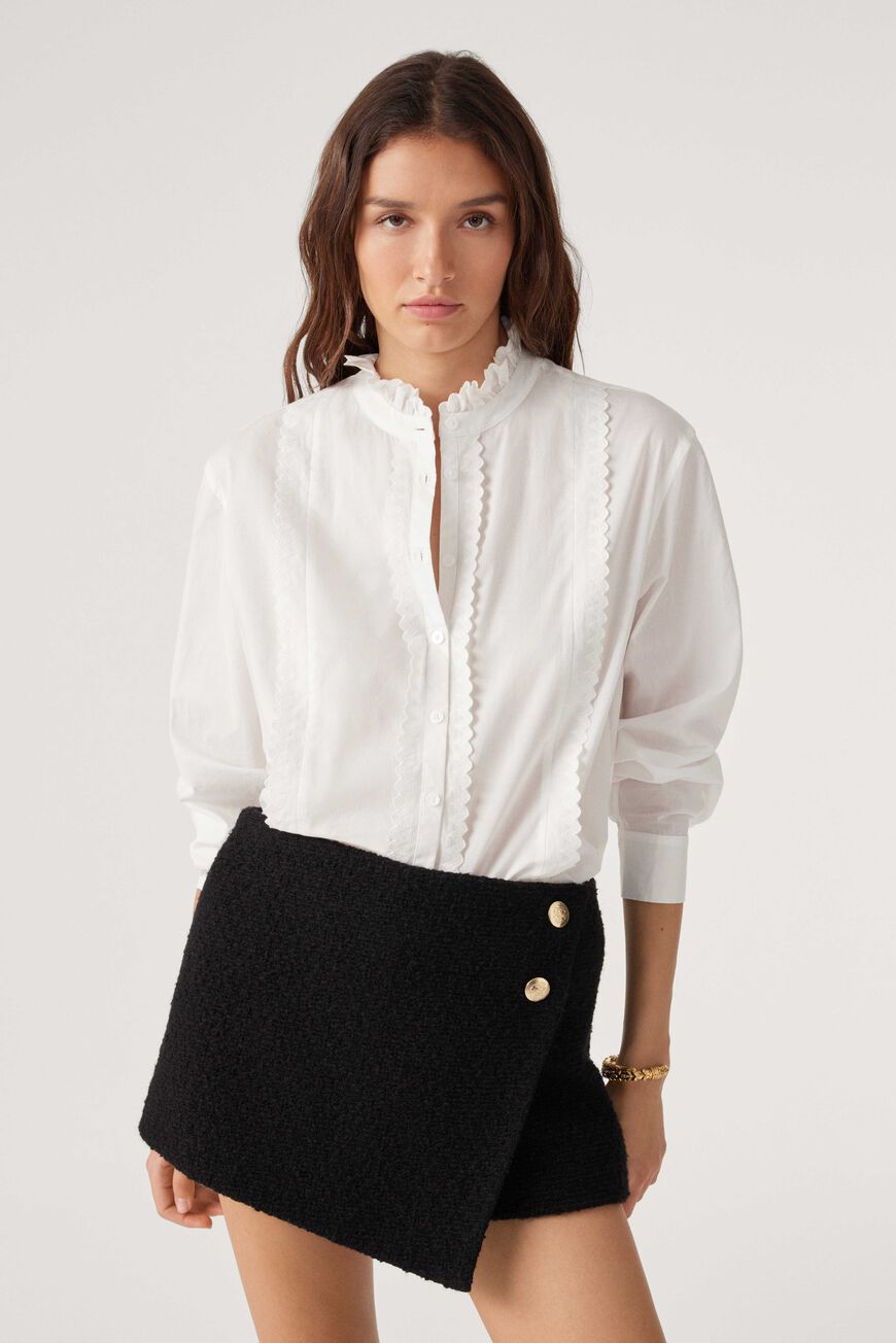 White shirt with ruffle collar long sleeves and ruffles down the front