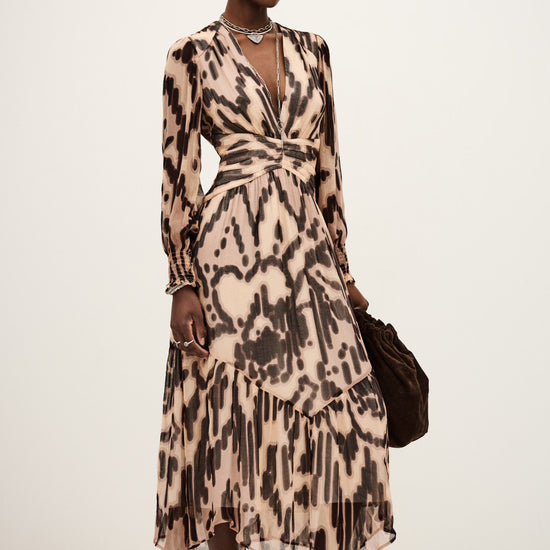 Woman wearing a patterned dress with a plain background