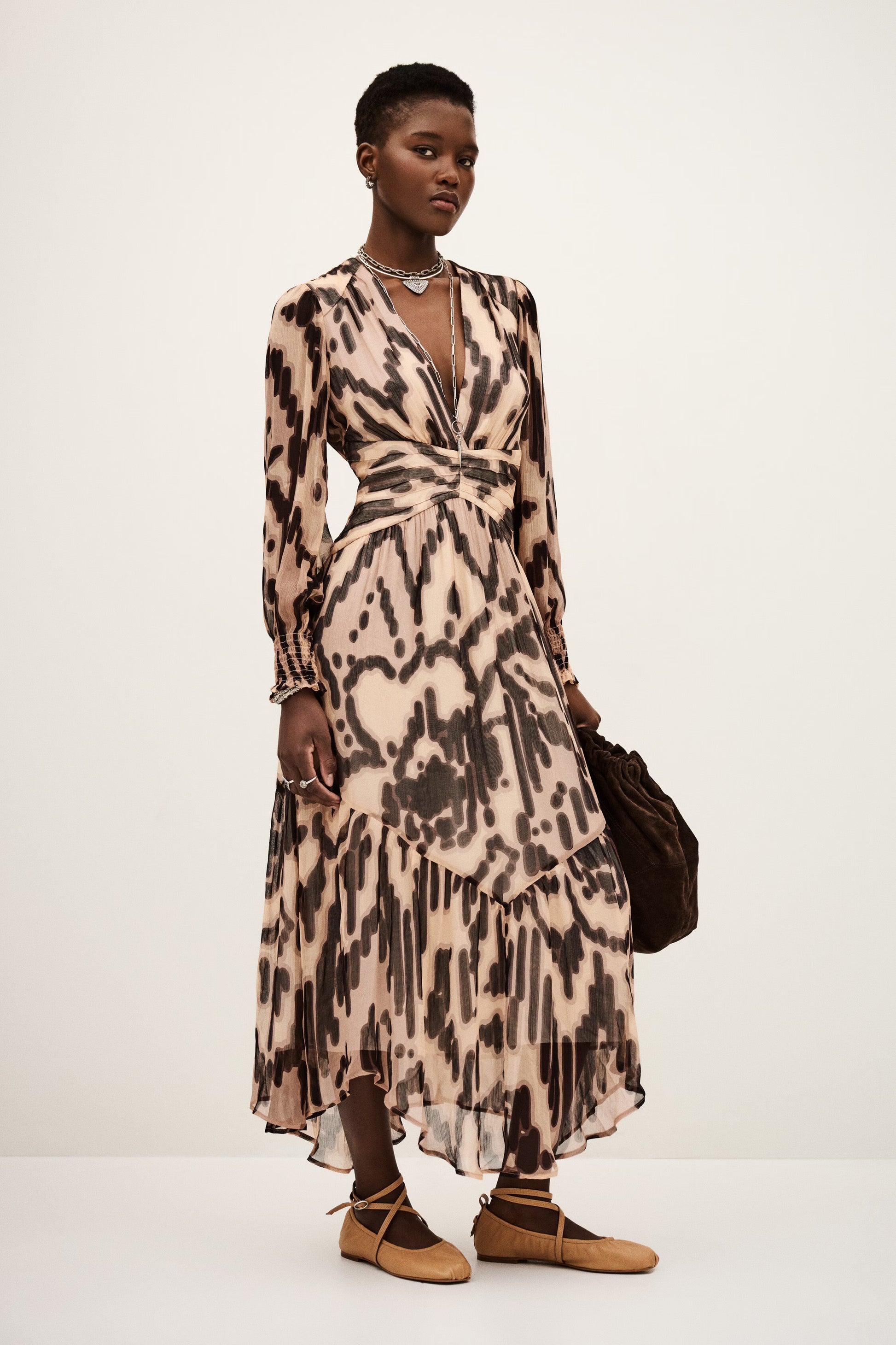 Woman wearing a patterned dress with a plain background