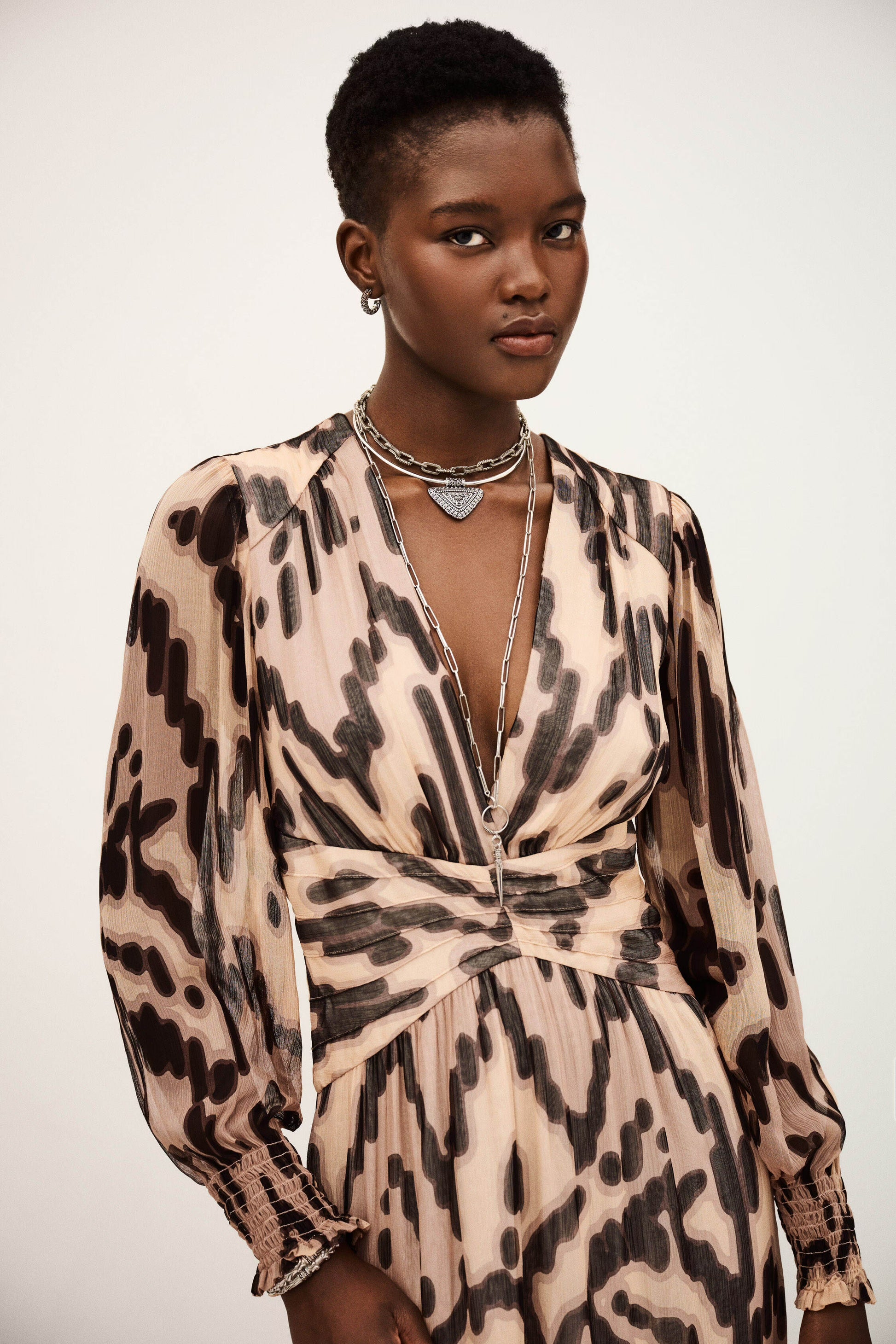Woman wearing a leopard print dress with a plain background