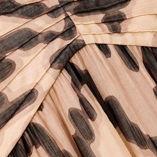 Close-up of a pleated fabric with a brown and beige pattern
