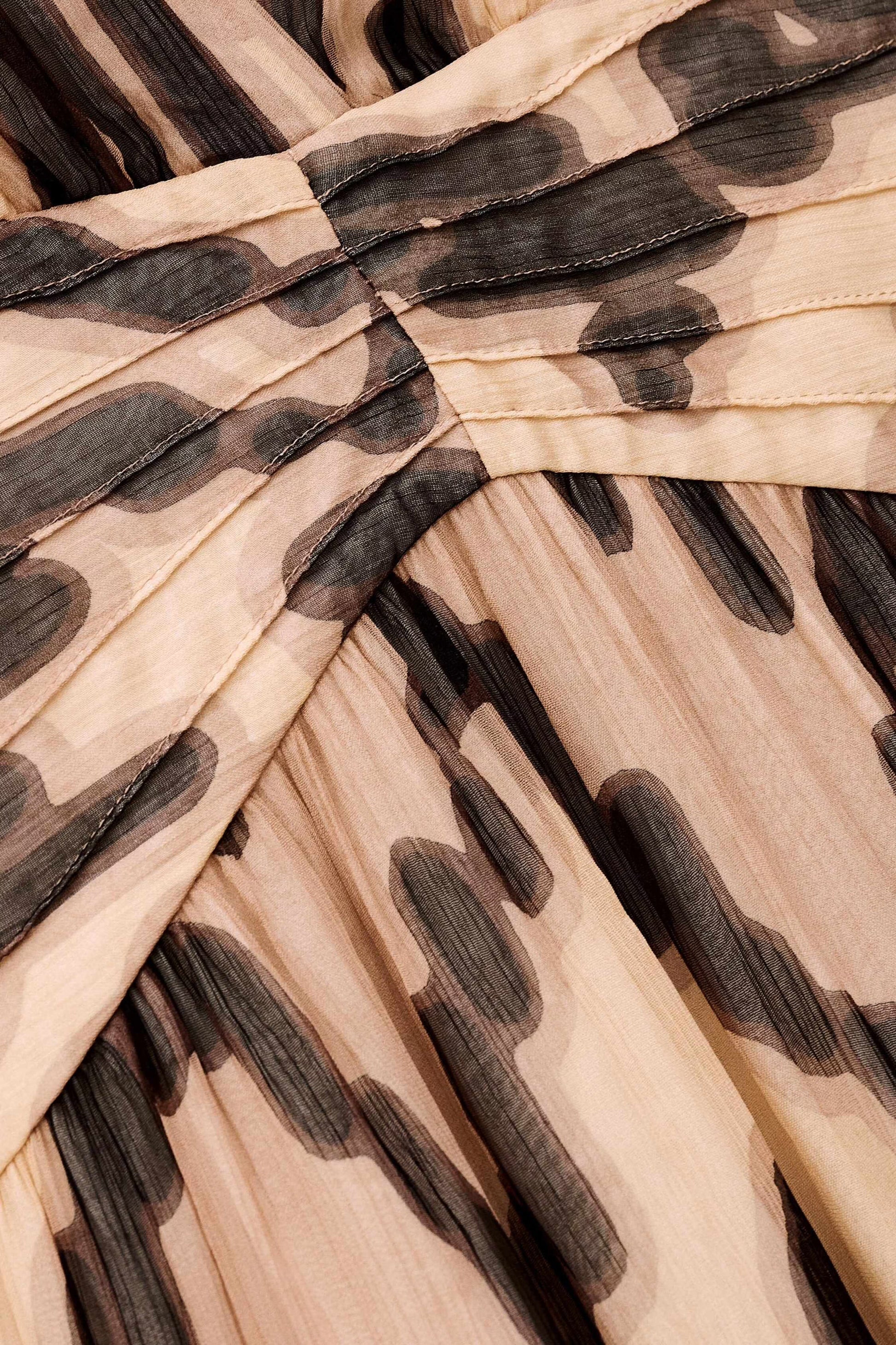 Close-up of a pleated fabric with a brown and beige pattern