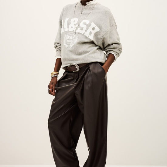 Person wearing a gray sweatshirt with 'A&SR' branding and dark pants on a white background