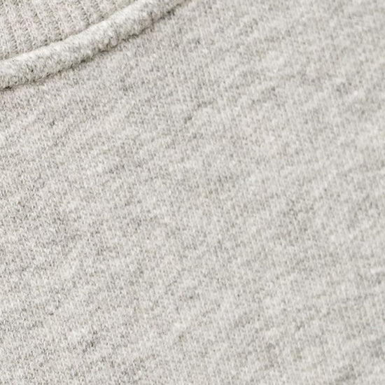 Close-up of a light heather gray knit fabric with a ribbed crew neck collar.