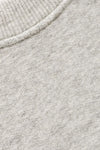 Close-up of a light heather gray knit fabric with a ribbed crew neck collar.